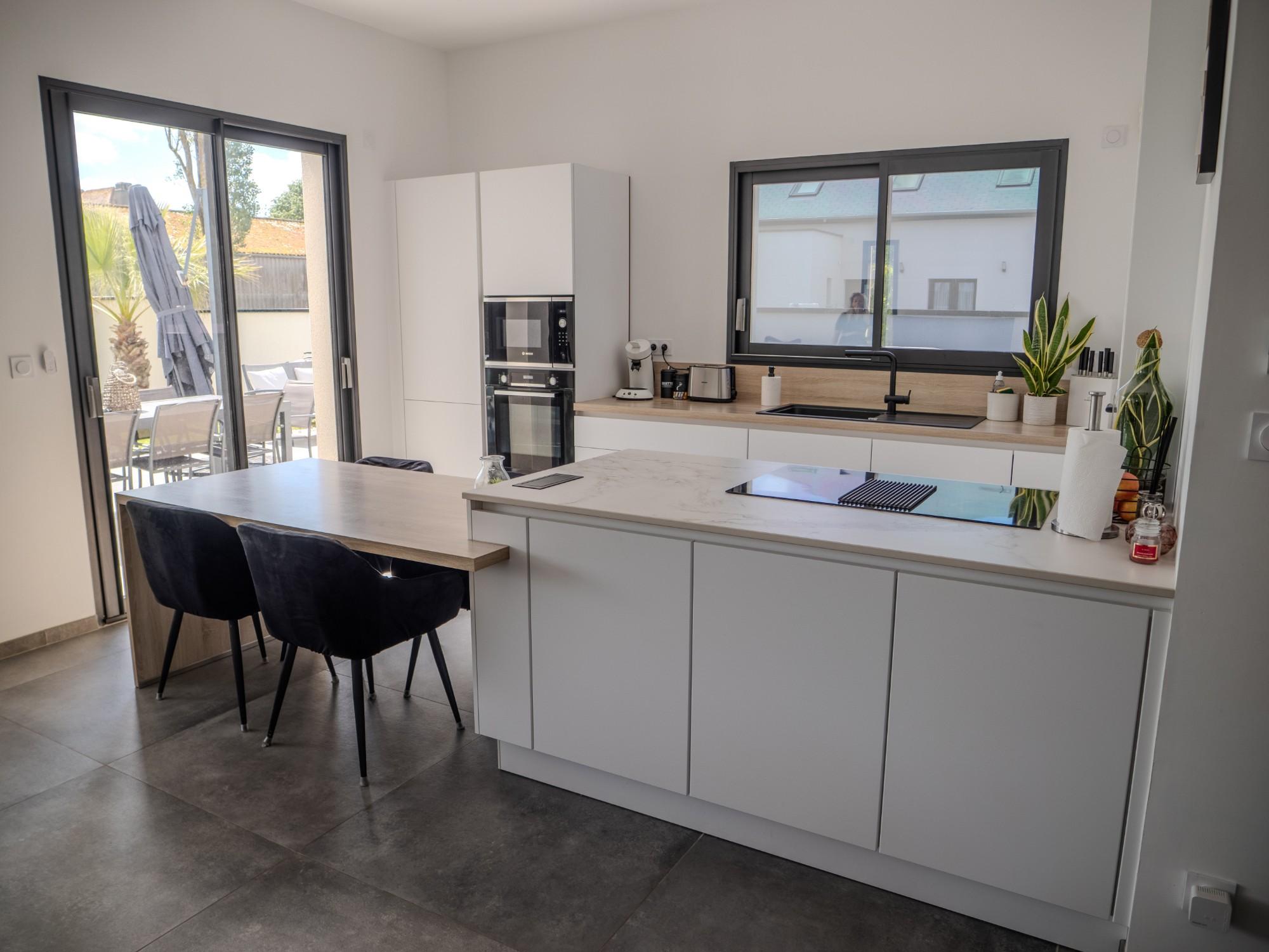 Cuisine blanche avec îlot ouverte sur la terrasse