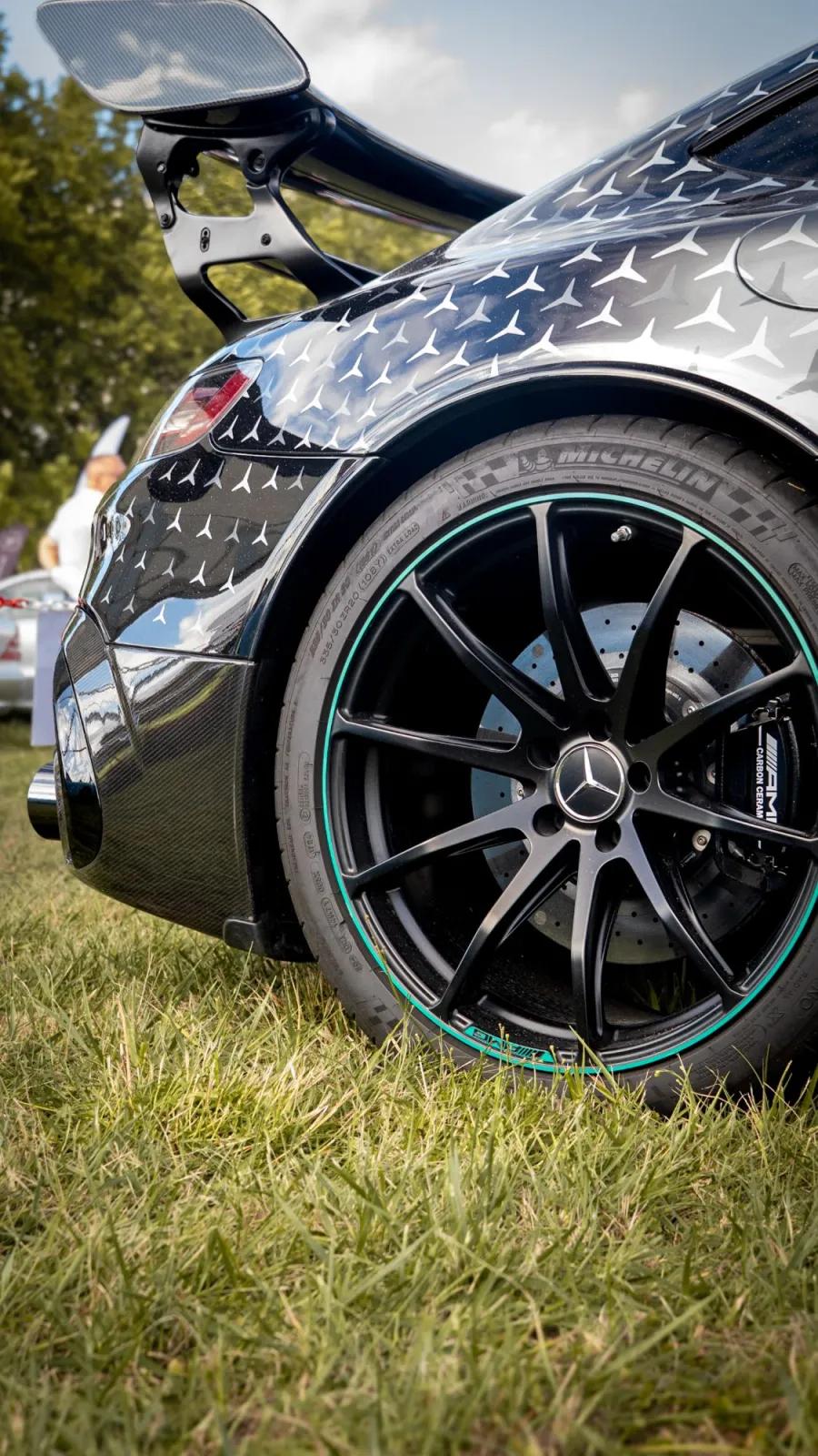 Roue et aileron d'une Mercedes-AMG GT, photographiés au ras de l'herbe